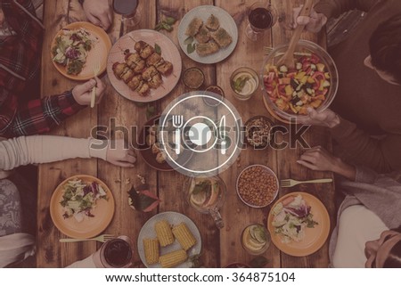 Dinner is served. Digitally composed picture of kitchen utensil over top view of four people having dinner together while sitting at the rustic wooden table