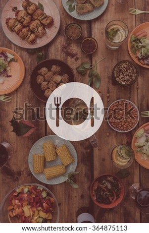 Lunch time. Digitally composed picture of kitchen utensil over top view of rustic wooden table full of food and drinks