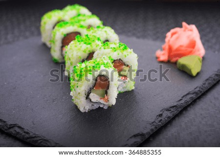 Sushi roll with salmon and green caviar
