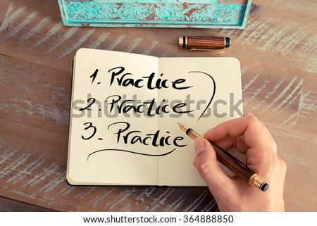 Retro effect and toned image of a woman hand writing a note with a fountain pen on a notebook. Handwritten text PRACTICE, business success concept Royalty-Free Stock Photo #364888850