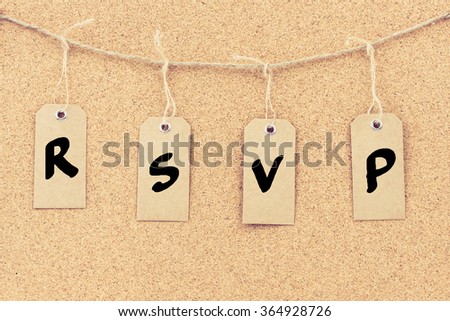 Vintage grunge tags with letters on rope string, word RSVP over cork board texture background, filter applied, available copy space. 