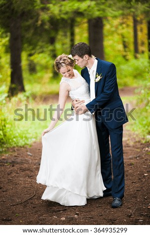 Happy bridal couple in forest. Summer wedding picture.