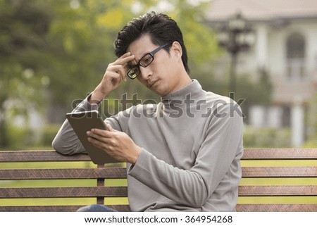 Man use tablet and thinking at park