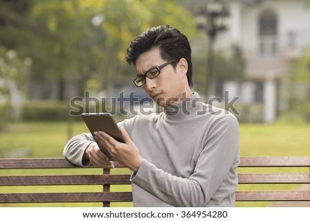 Man use tablet and thinking at park