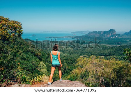 Girl on the view point of the mountain, standing back infront of camera, concept of freedom and traveling. Traveler enjoying the landscape from mountain, Tab Kak Hang Nak Nature Trail, Krabi, Thailand Royalty-Free Stock Photo #364971092