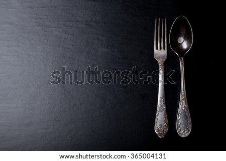 Metal fork and spoon on a black background.