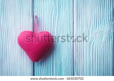 Fabric heart over blue wooden background