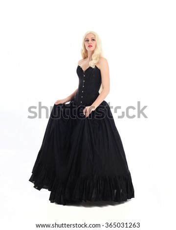 blonde haired woman wearing a long black gown with corset. isolated on white background.