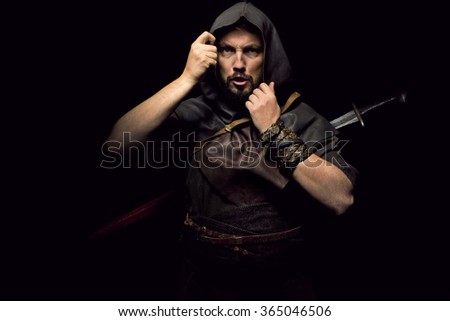 Man dressed in barbarian style with sword and hood, bearded