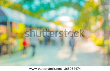 Blurred image of people walking at day market in sunny day, blur background with bokeh .