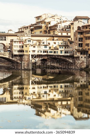 Ponte Vecchio and historic buildings are mirrored in the river Arno, Florence, Tuscany, Italy. Travel destination. Cultural heritage.