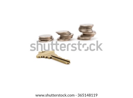 Old golden key with stack of coins isolated on white