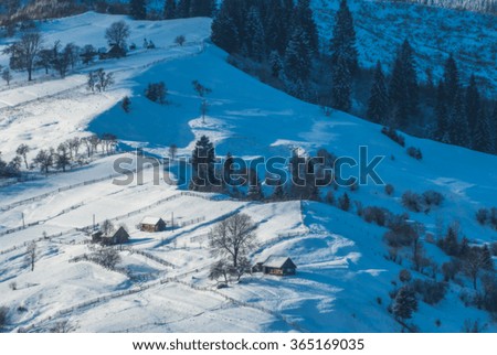 Carpathian village on a mountain hill covered by fresh january snow. Winter landscape. Ukraine, Europe