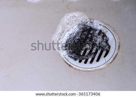 Hair clump in bath drain while taking a shower. Royalty-Free Stock Photo #365173406