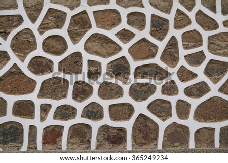 wall of brown stones in whtie stucco