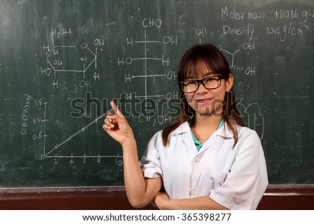 Young female scientist and molecular structure on black board