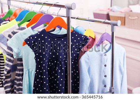 Children clothes on hangers in a room