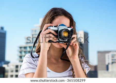 Young girl taking photos in town in a sunny day