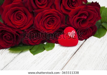 Beautiful red roses with heart on a white wooden background
