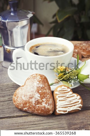 Heart shaped cookies , cup of coffee, white rose decoration, coffee maker. Romantic or Valentine's Day Breakfast. Toned, selected focus image