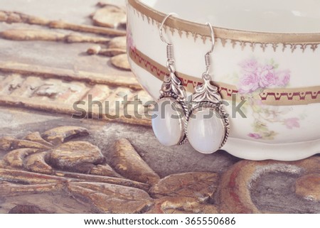 Beautiful shiny earrings hanging on the vintage background