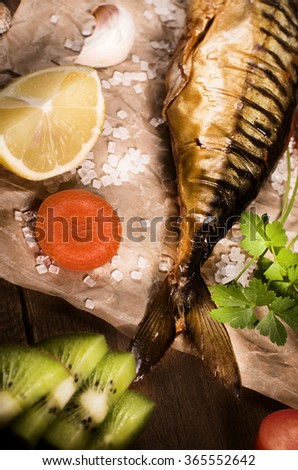 Smoked mackerel with lemon on paper, top view cocking background.