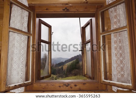 a view from an open window of a mountain cabin