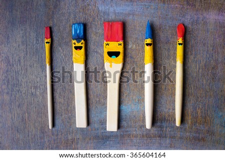 Five smile brushes on table. Smile sign on brushes. Happy an fun smile symbols on colored and painted brushes. 