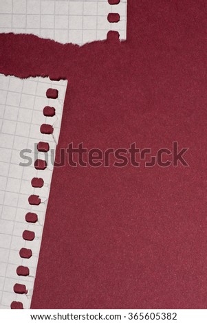 Pieces of white torn paper over the dark red background