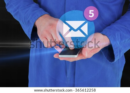 Mechanic using mobile phone against glowing abstract design