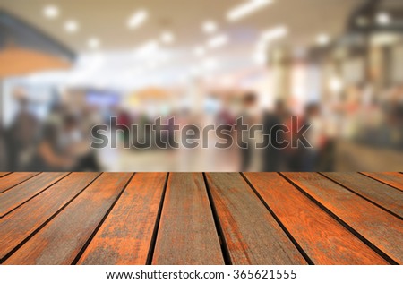 blurred image wood table and abstract department store shopping mall center and people background