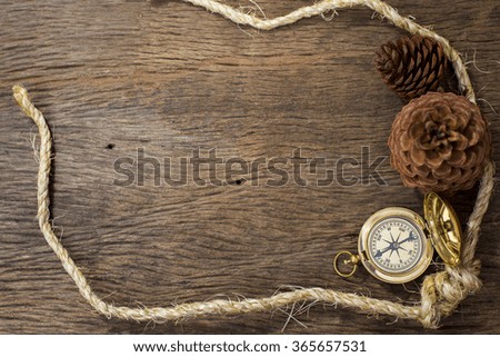 Old Compass and rope on wood background 