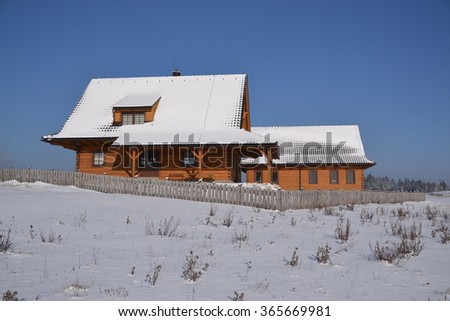 Wooden cottage in the sunny winter day
