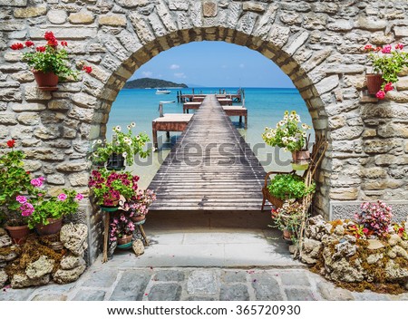 Seaview through the stone arch with flowers in Italy Royalty-Free Stock Photo #365720930