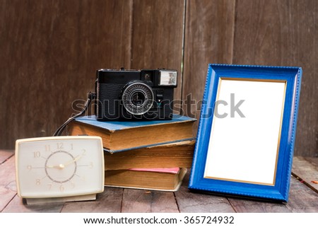 Empty Frame With Old Books and old camera on Brown Wood Table
