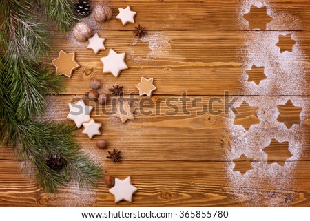 Gingerbread cookies stars on wooden festive background with spices and sugar powder as a snow. Christmas background for the greeting card.