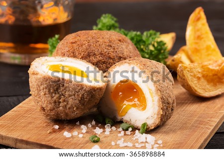 Traditional scotch eggs on a wooden plate Royalty-Free Stock Photo #365898884