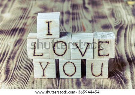 Wooden cubes with inscription "I LOVE YOU" on new wooden background. Selective focus. Toned.