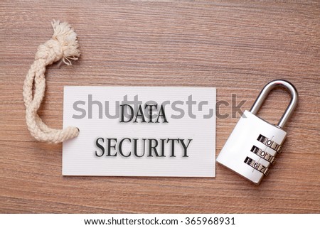 Combination number padlock on wood background with data security written on label tag