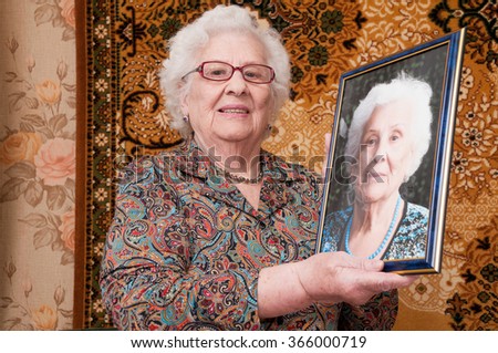 Senior woman proudly shows her portrait made recently