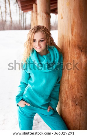 Portrait of beautiful blonde woman in blue sport suit  looking at camera