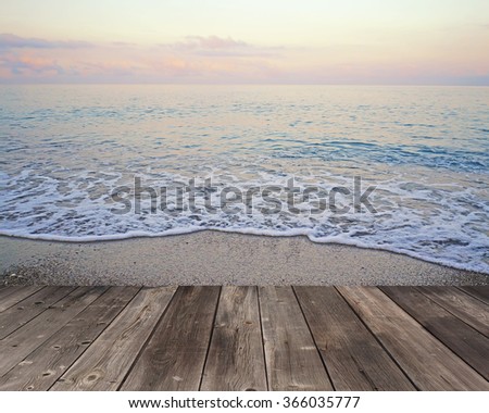 Empty wooden flooring against a summer decline at the sea with the wave running on the coast.