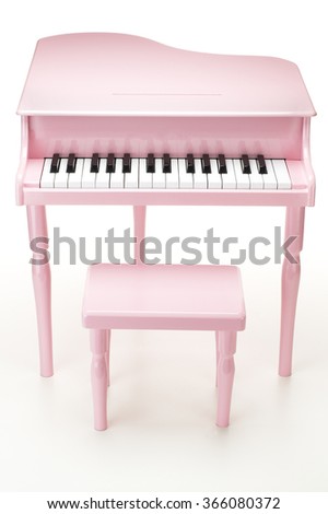Pink piano with stool on white background