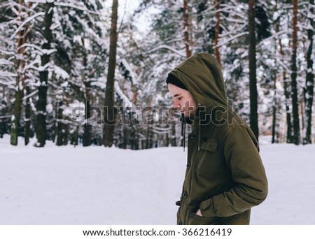Portrait of the young man in jacket in the forest