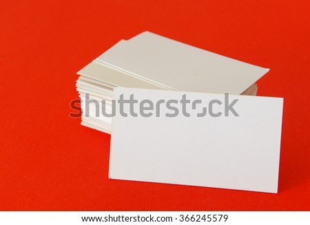 White blank business visit card, gift, ticket, pass, present close up on red background. 