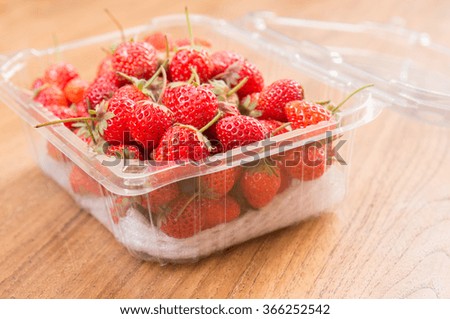 Fresh red strawberries on transparent package.