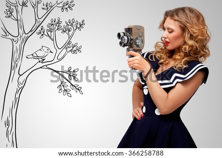 Glamorous pin-up sailor girl filming nature and wildlife with an old retro cinema 8 mm camera, standing in front of a bird on grey sketchy background.