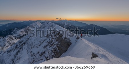 Beautiful sunrise in the winter mountains. Male hiker waiting for the sunrise.