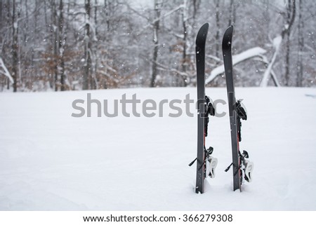 Winter landscape on mountain, ski in the snow. In the moment of taking a picture, it snowed. In the background is forest covered with snow