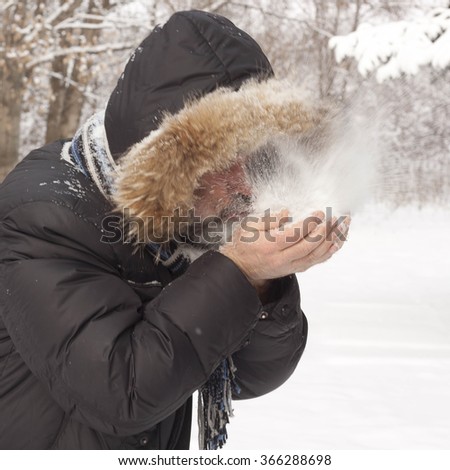 Man blowing on snow in hands